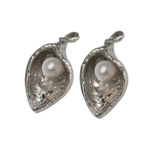 Handcrafted sterling silver earrings with organic sculptural shape cradling a freshwater pearl, available in white or black.