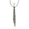 Long pendant necklace featuring a vertically elongated sculptural form wrapped in intersecting darkened metal bands, accented with small gold drops throughout, suspended from a black cord with a textured gold ring at the top and finished with an organic pearl at the base.