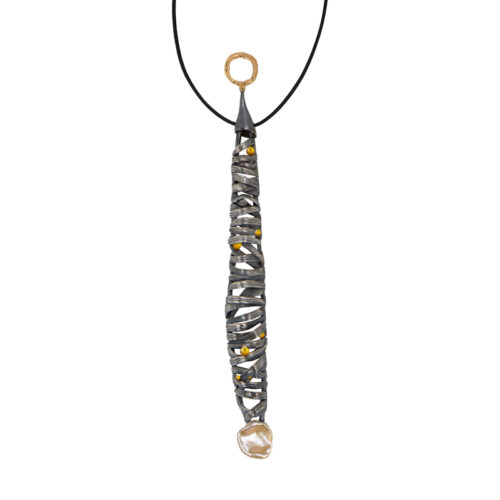 Long pendant necklace featuring a vertically elongated sculptural form wrapped in intersecting darkened metal bands, accented with small gold drops throughout, suspended from a black cord with a textured gold ring at the top and finished with an organic pearl at the base.