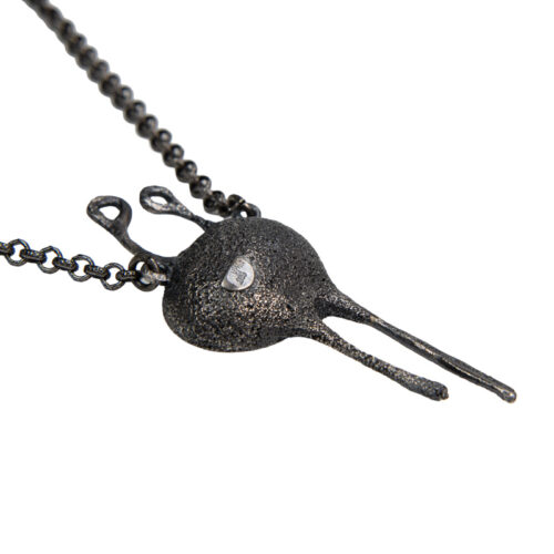 Handmade conceptual pendant in oxidized silver with small golden spheres, abstract organic form symbolizing repetition and the beginning of existence.